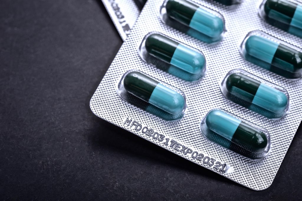 Expiration date on medicine blister pack on black background. For